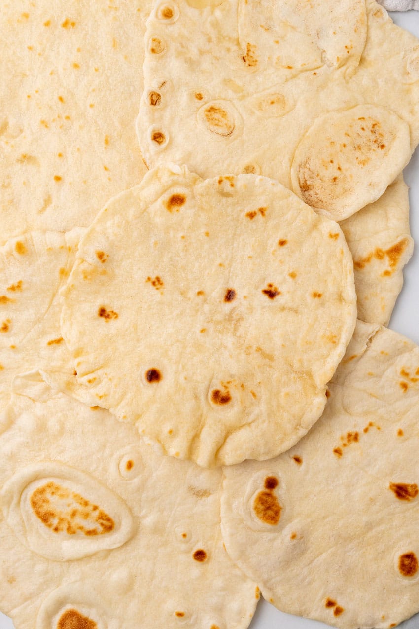 a pile of homemade flour tortillas