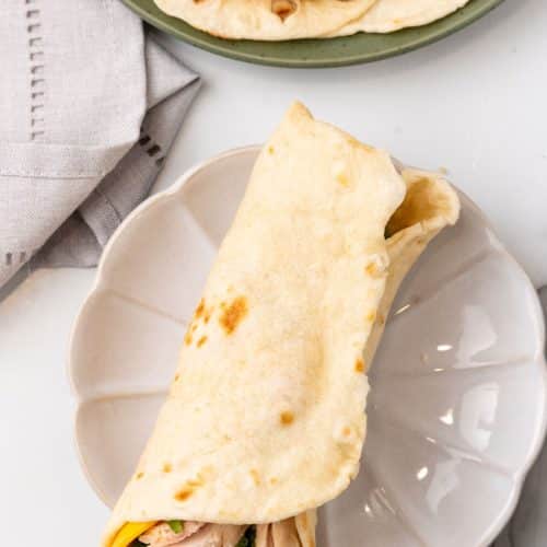 a chicken wrap on a small white plate
