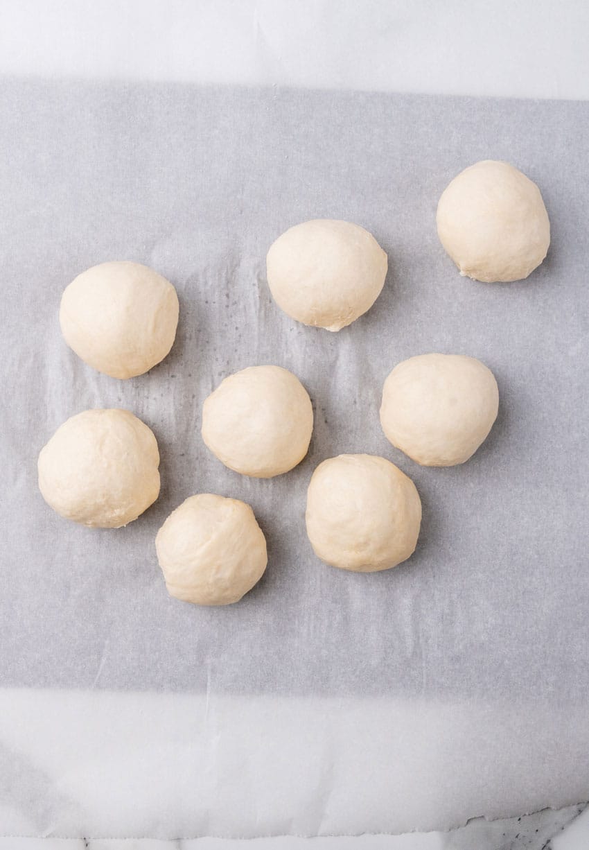 balls of flour tortilla dough on a piece of parchment paper