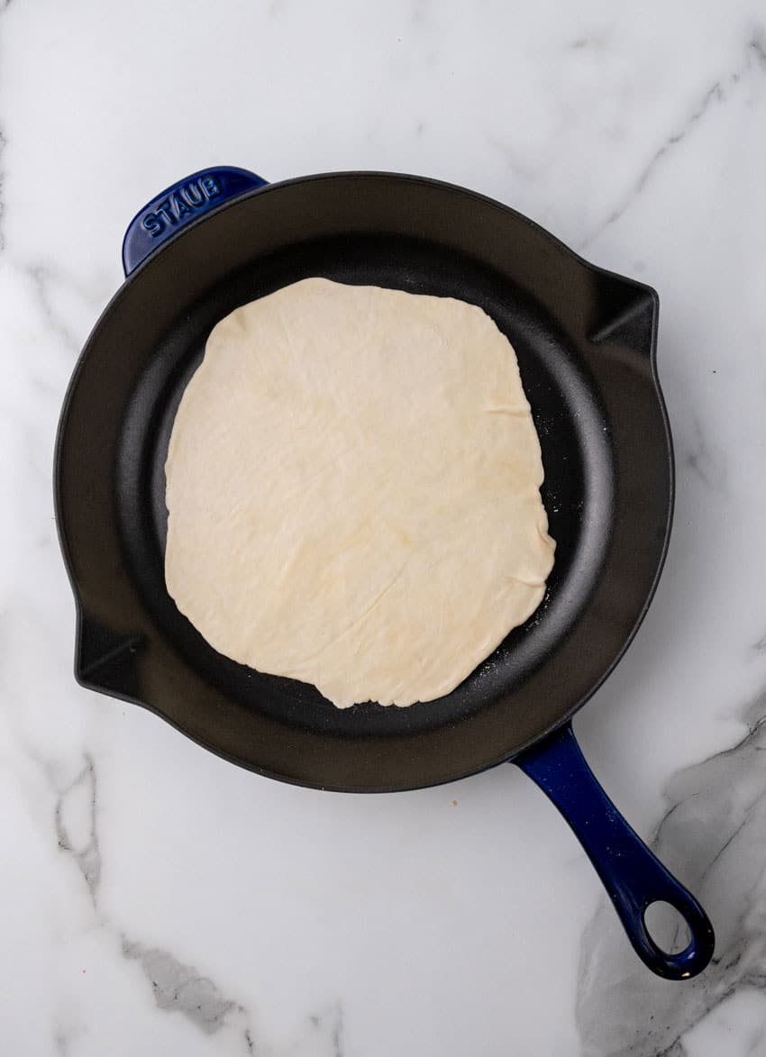 a homemade flour tortilla in a cast iron skillet