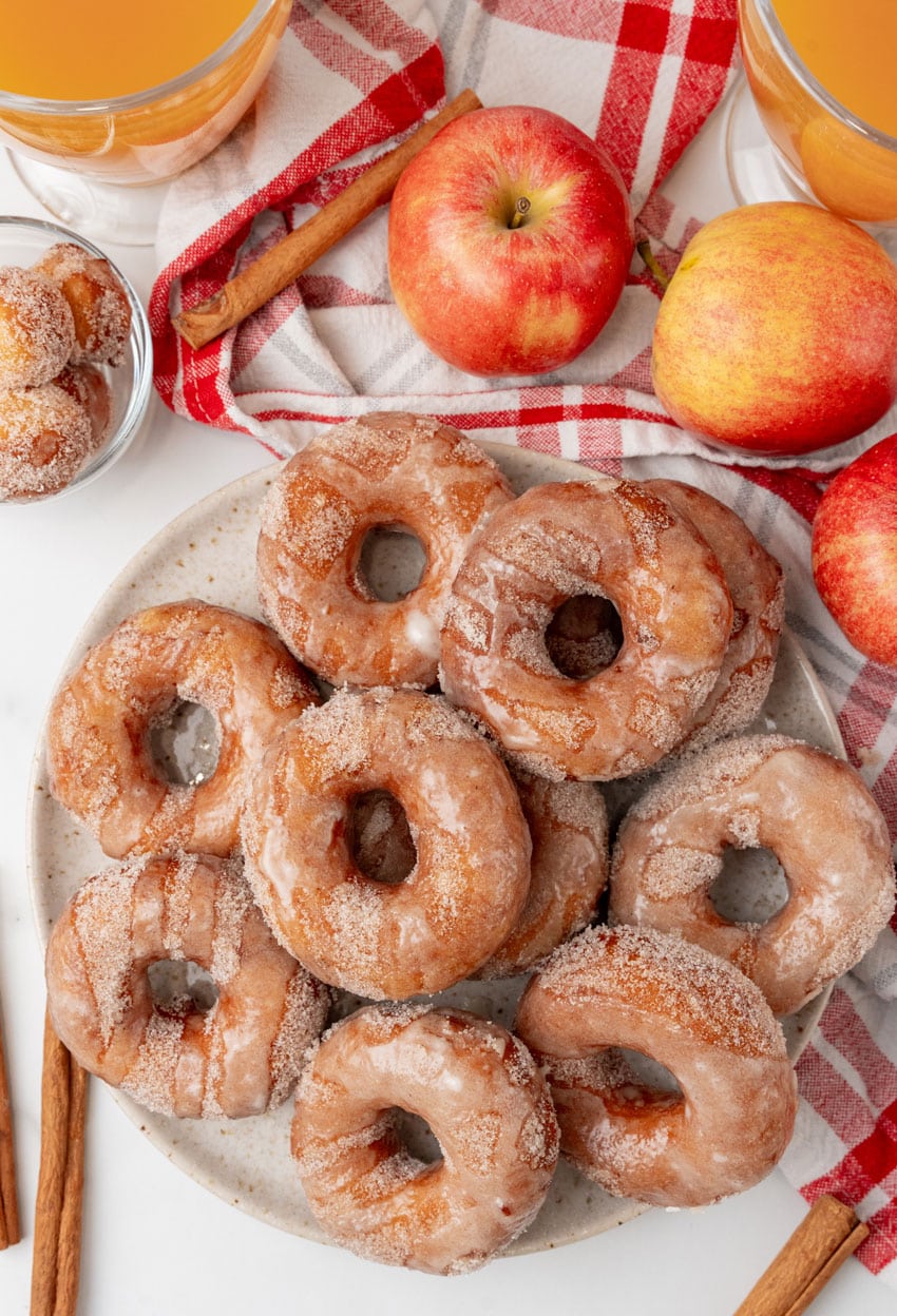 apple cider donuts stacked on a white serving plate