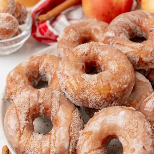 apple cider donuts stacked on a white serving plate