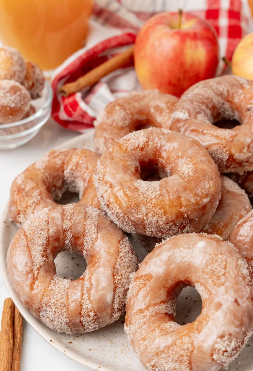 apple cider donuts stacked on a white serving plate
