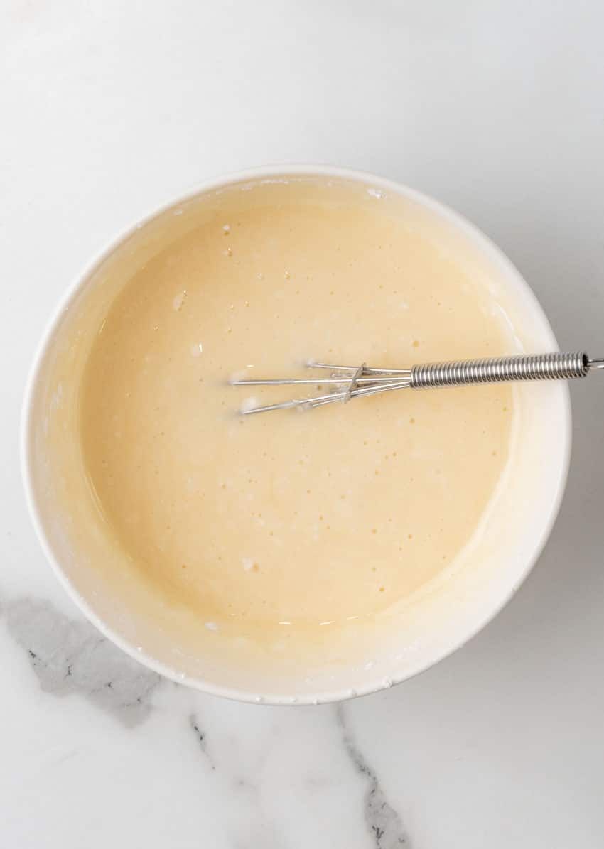 cream cheese glaze in a white mixing bowl