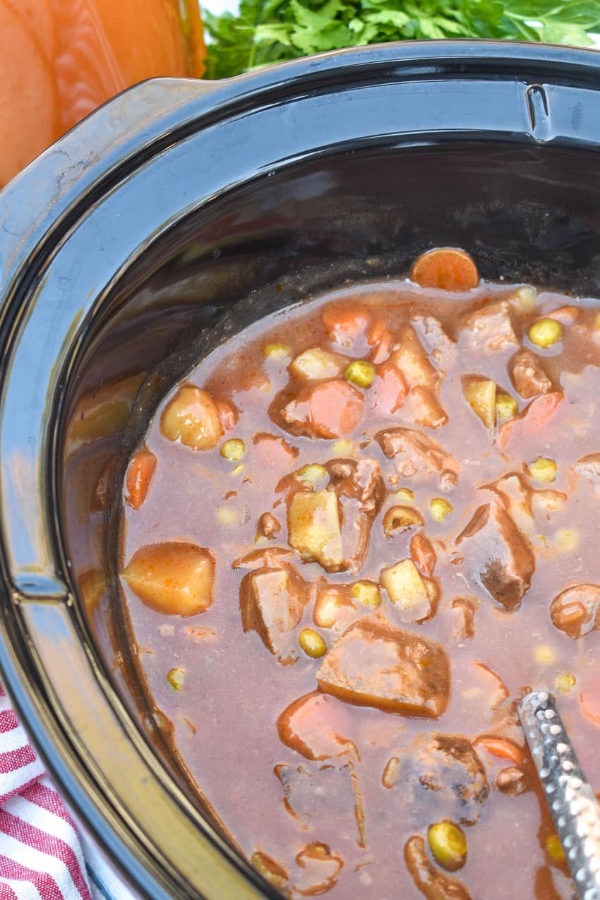 apple cider beef stew in the black bowl of a slow cooker