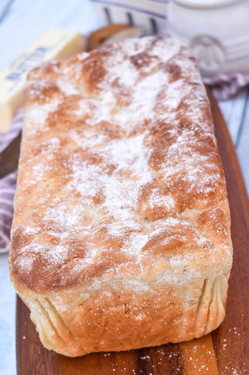 a loaf of homemade english muffin bread on a wooden cutting board