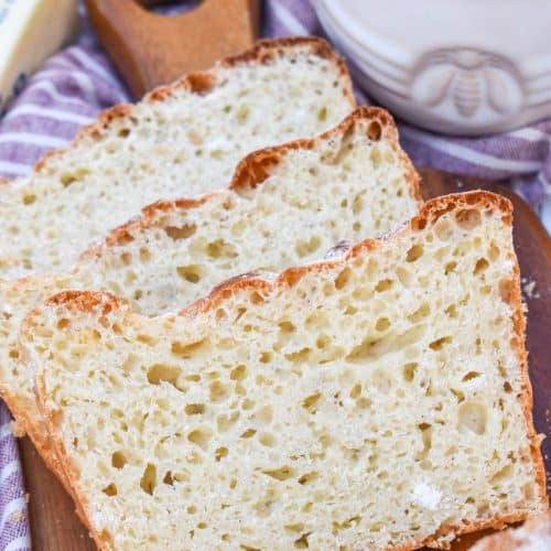 three slices of english muffin bread arranged in a row on a wooden cutting board