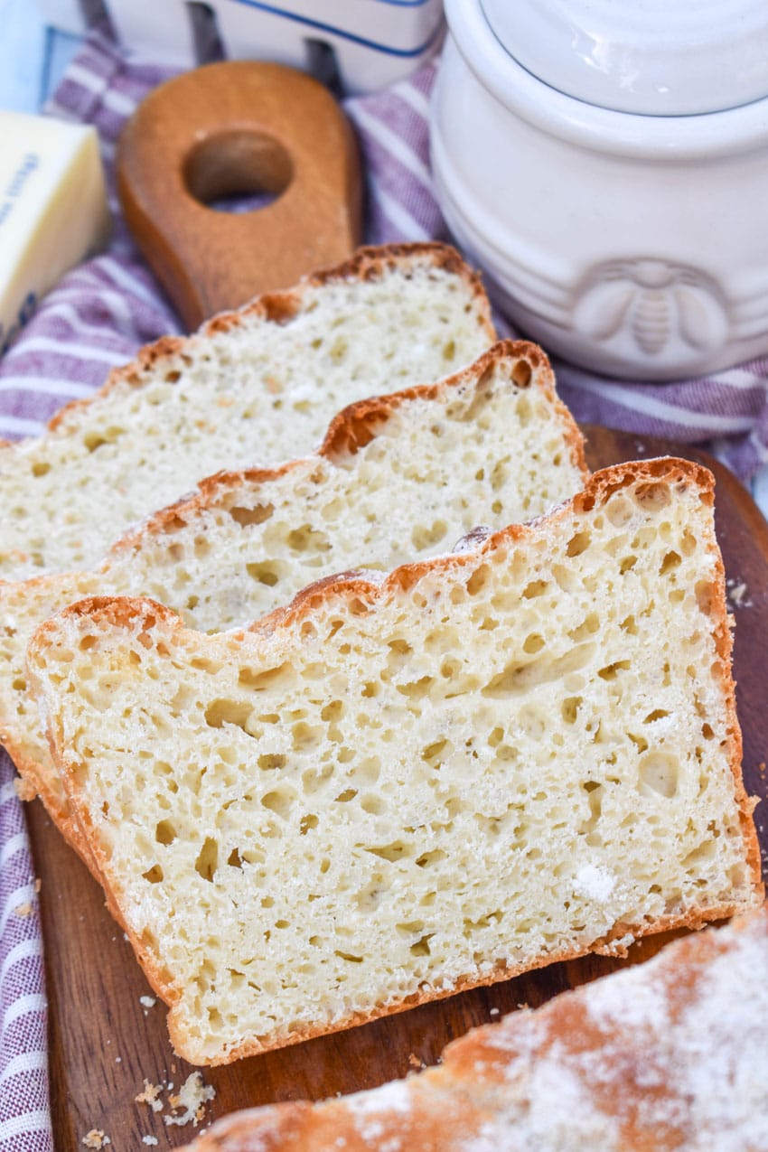 three slices of english muffin bread arranged in a row on a wooden cutting board