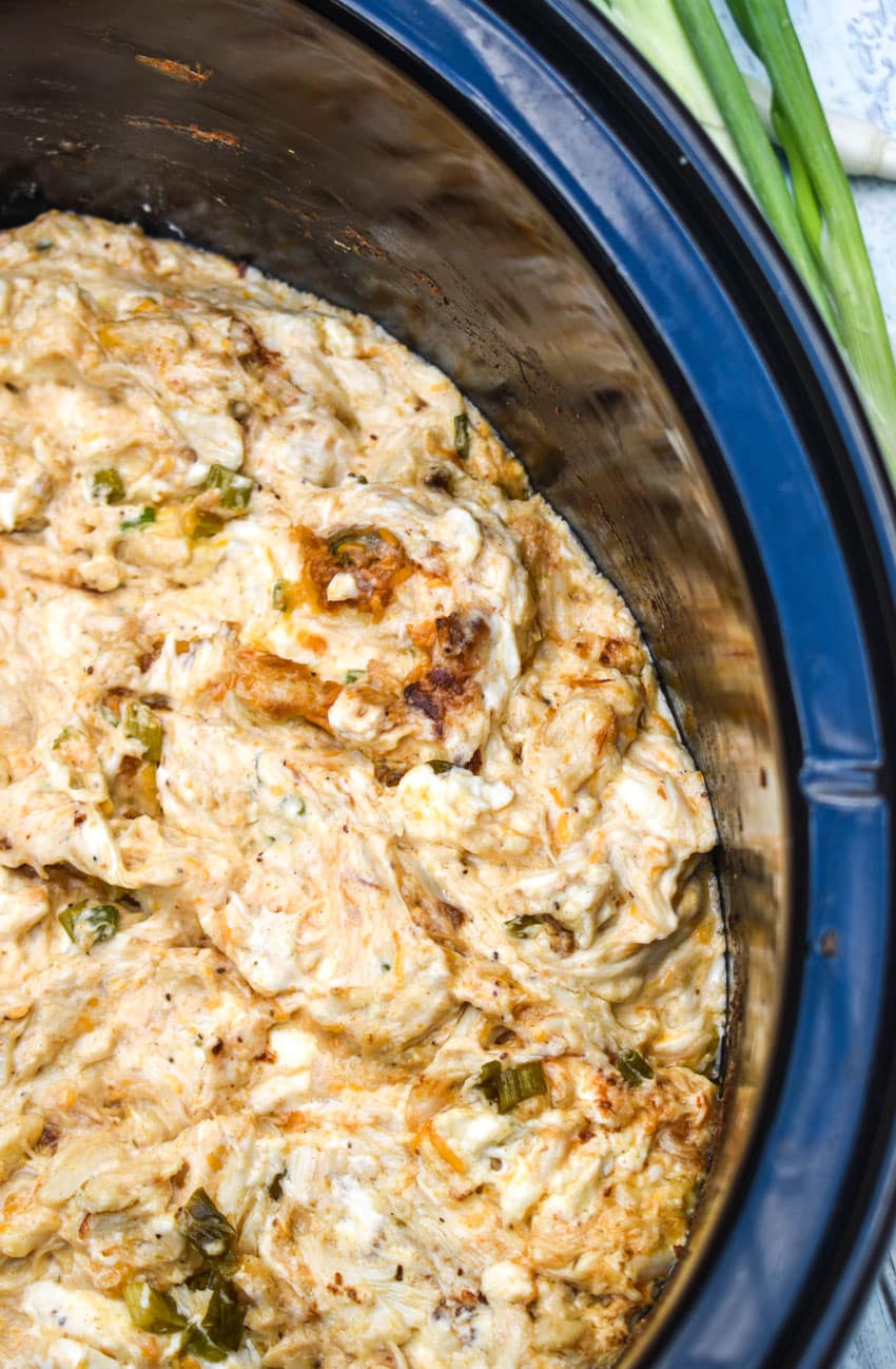 slow cooker creamy crab dip in the black bowl of a crockpot