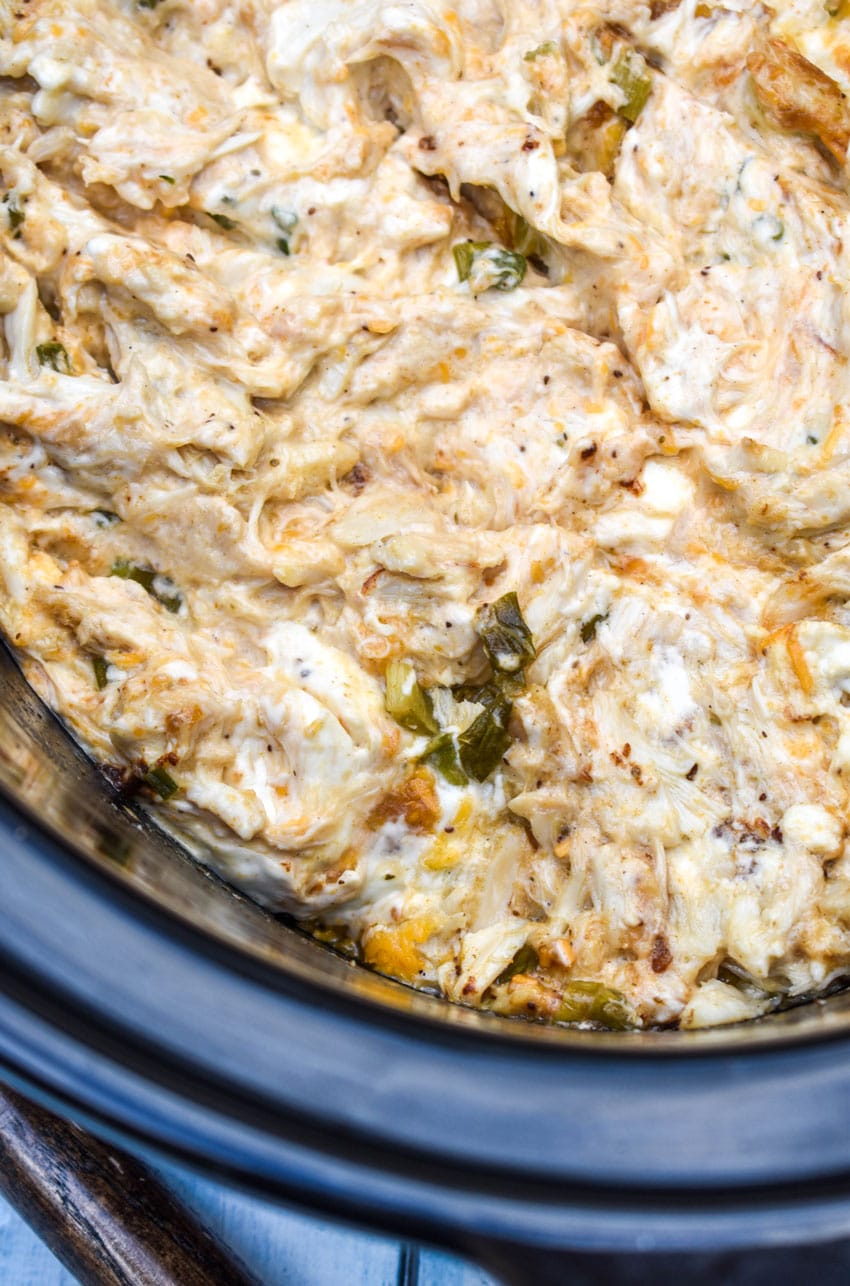 slow cooker creamy crab dip in the black bowl of a crockpot
