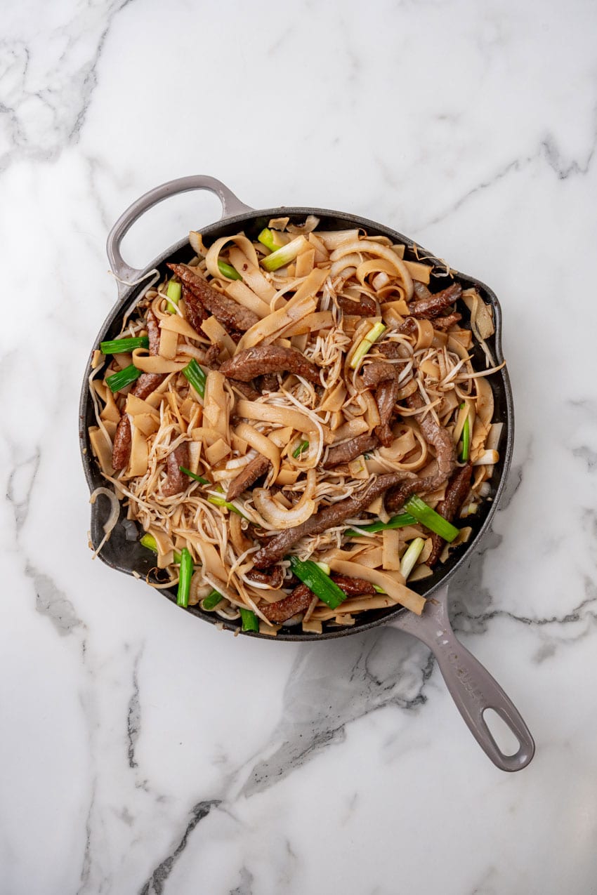 beef chow fun ingredients in a large cast iron skillet