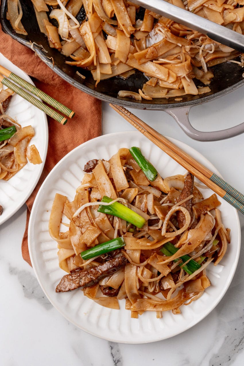 beef chow fun on two small white plates