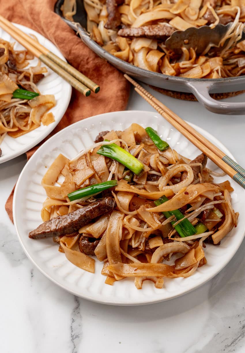 beef chow fun on two small white plates