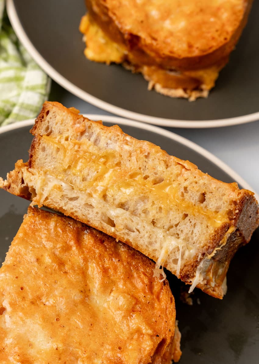 two halves of a tomato soup grilled cheese on a black plate