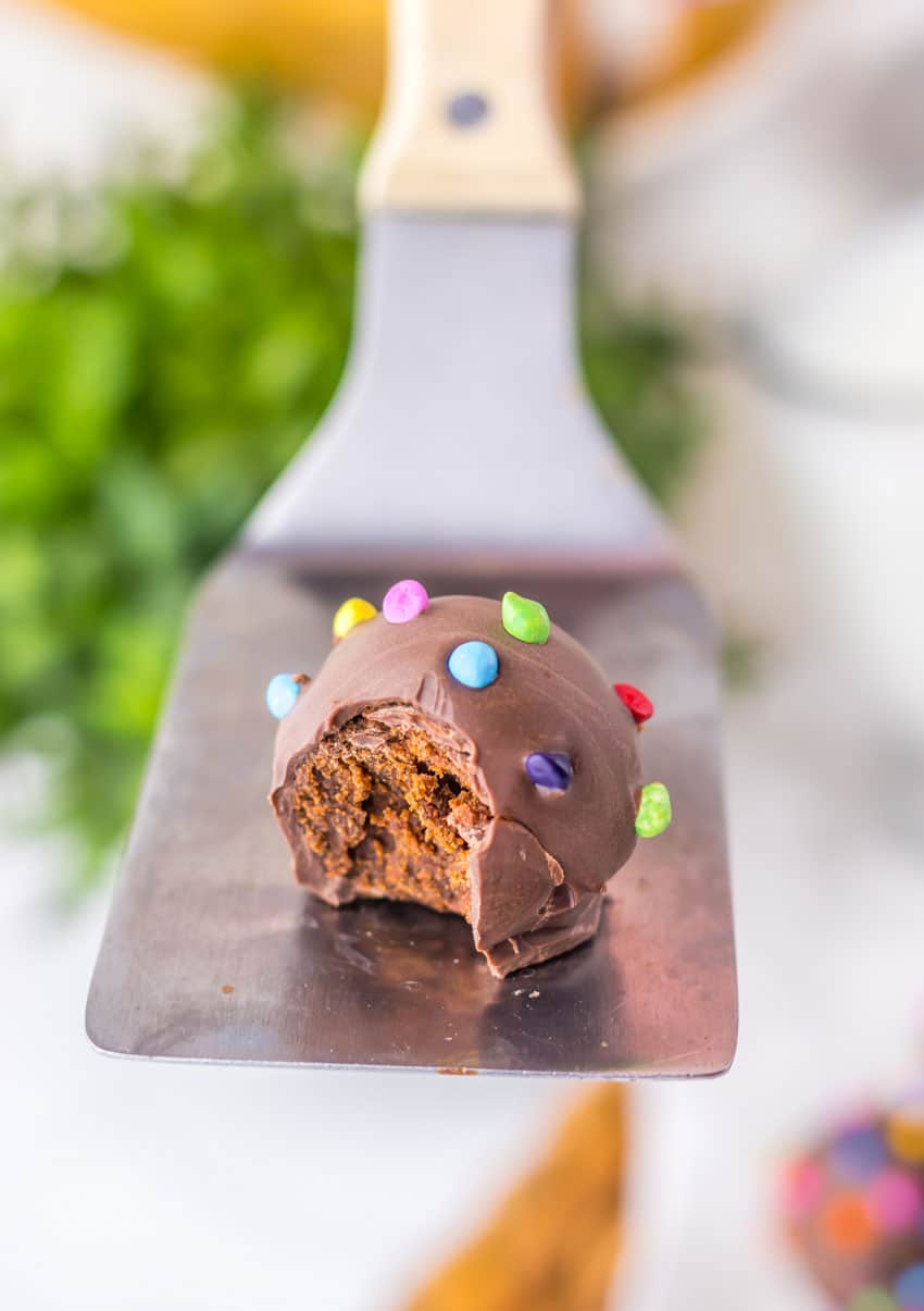 a spatula holding up a bitten cosmic brownie truffle