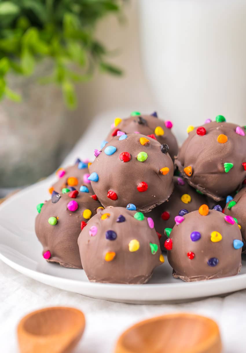 cosmic brownie truffles piled on a small white dessert plate