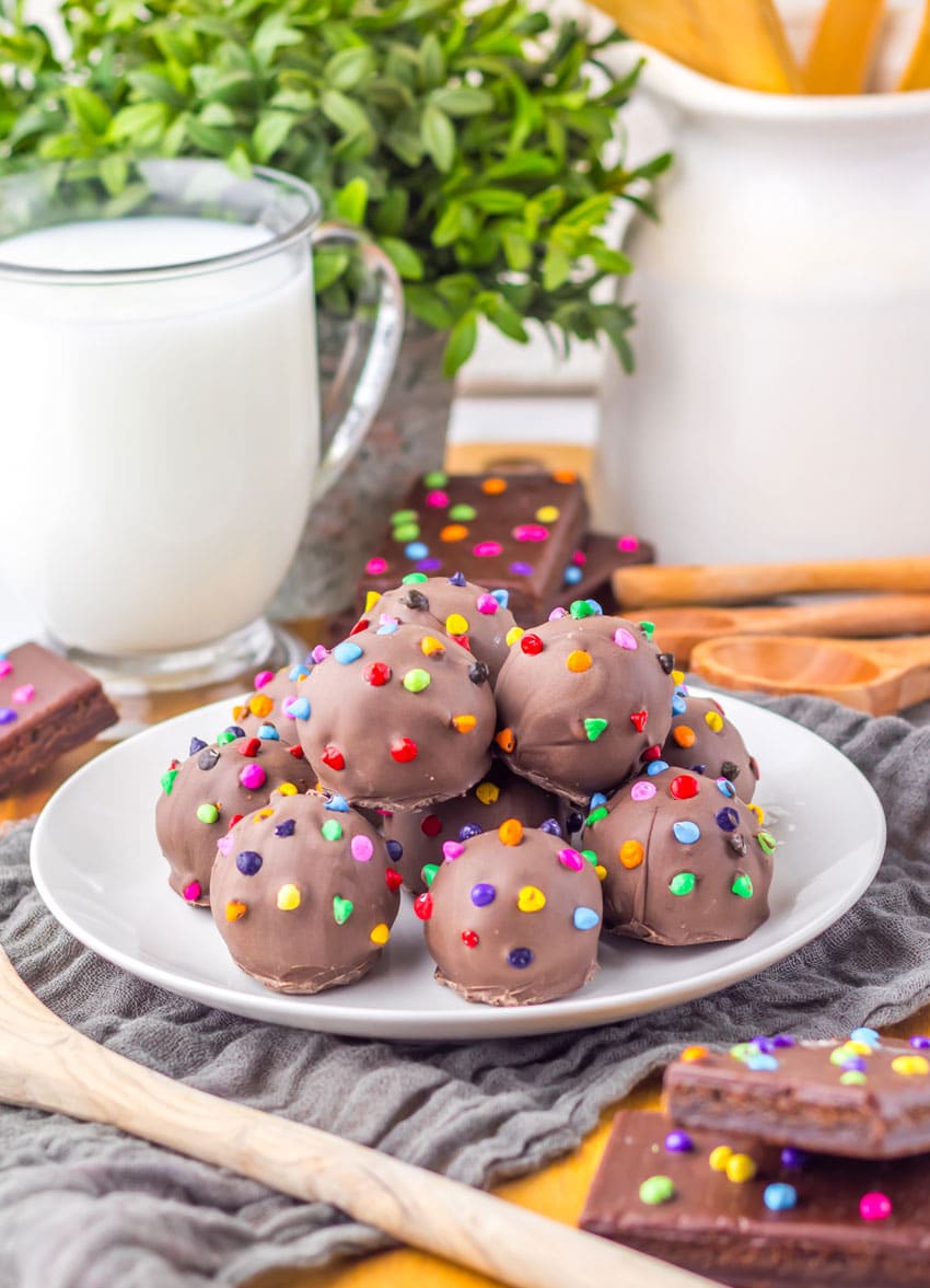 cosmic brownie truffles piled on a small white dessert plate