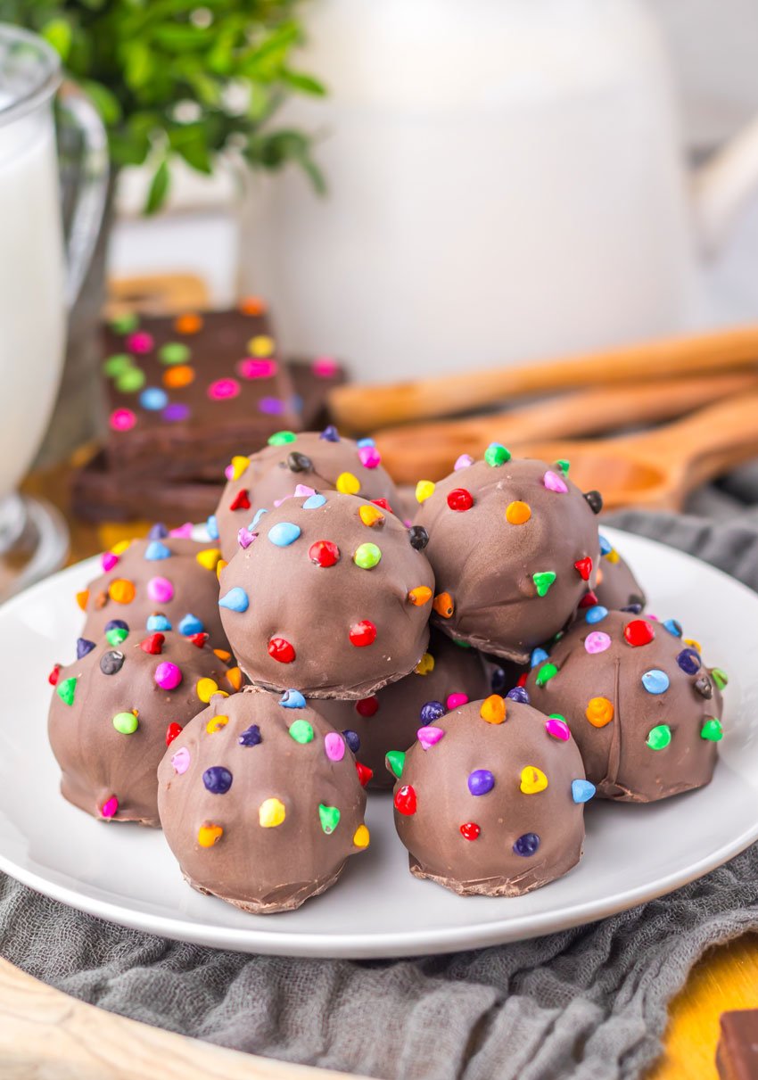 cosmic brownie truffles piled on a small white dessert plate