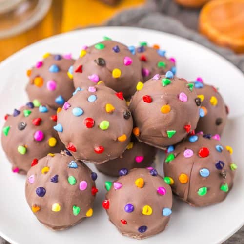 cosmic brownie truffles piled on a small white dessert plate