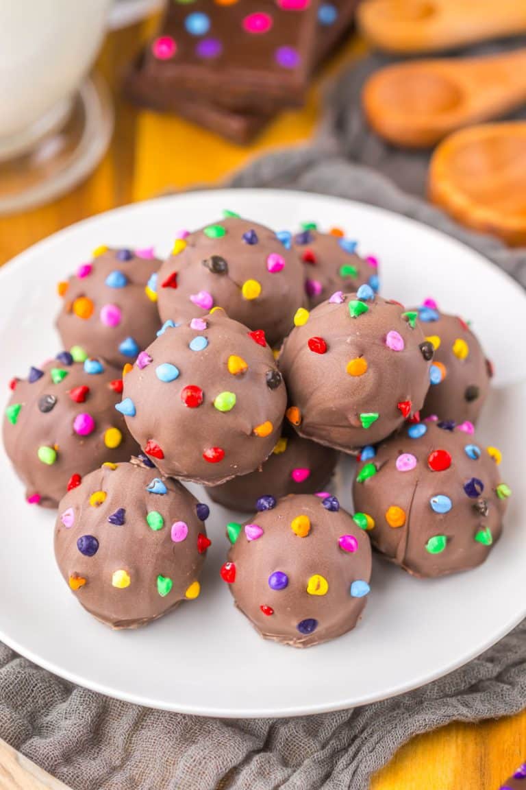 cosmic brownie truffles piled on a small white dessert plate