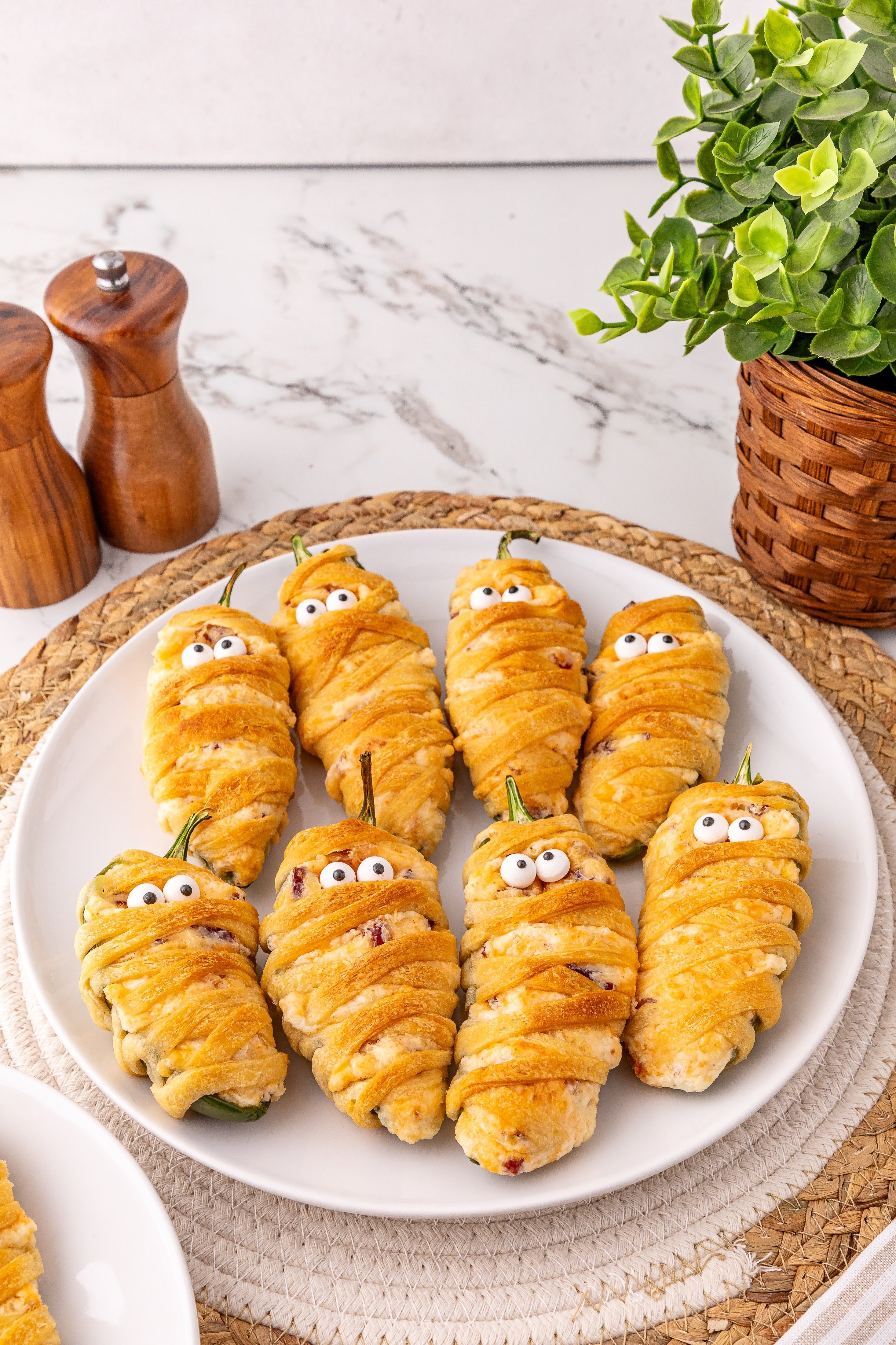 jalapeno popper mummies on a white serving plate