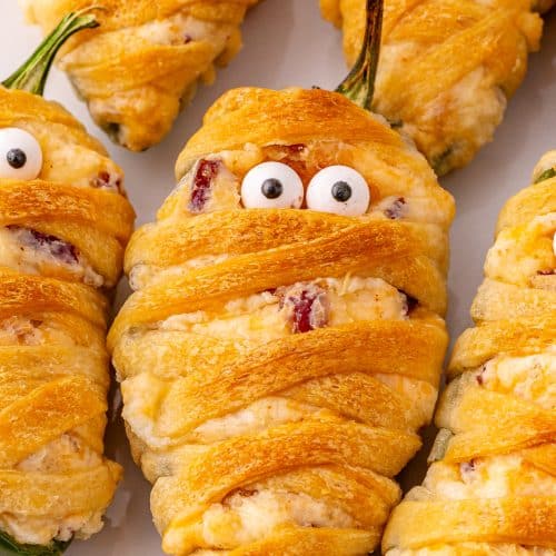 a close up image of jalapeno popper mummies on a white plate