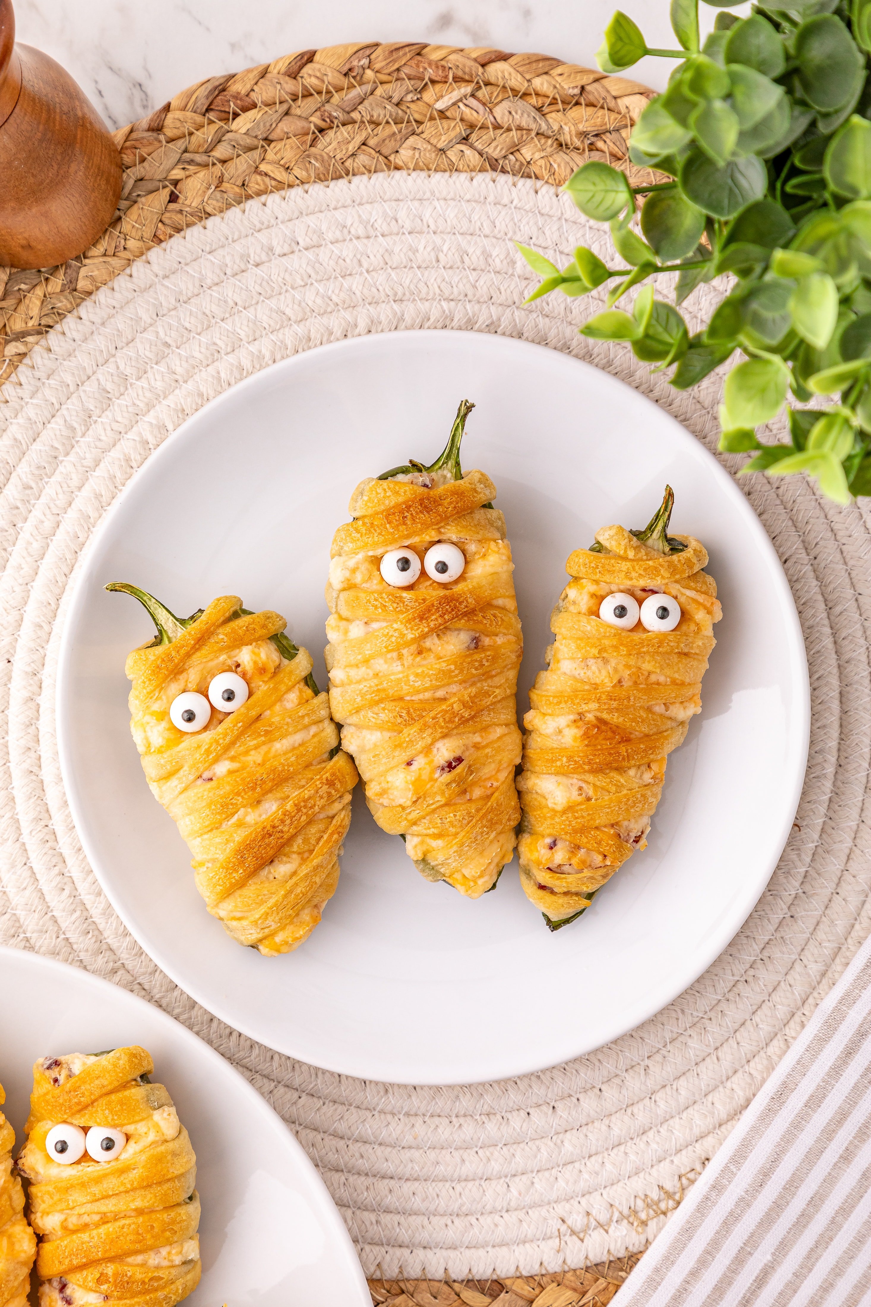 jalapeno popper mummies on a white serving plate