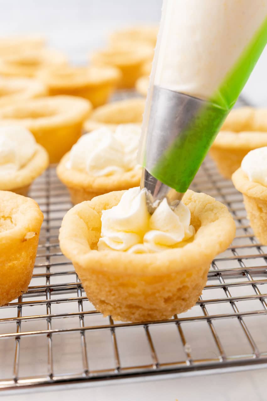 whipped pudding cream filling being piped into a homemade sugar cookie cup