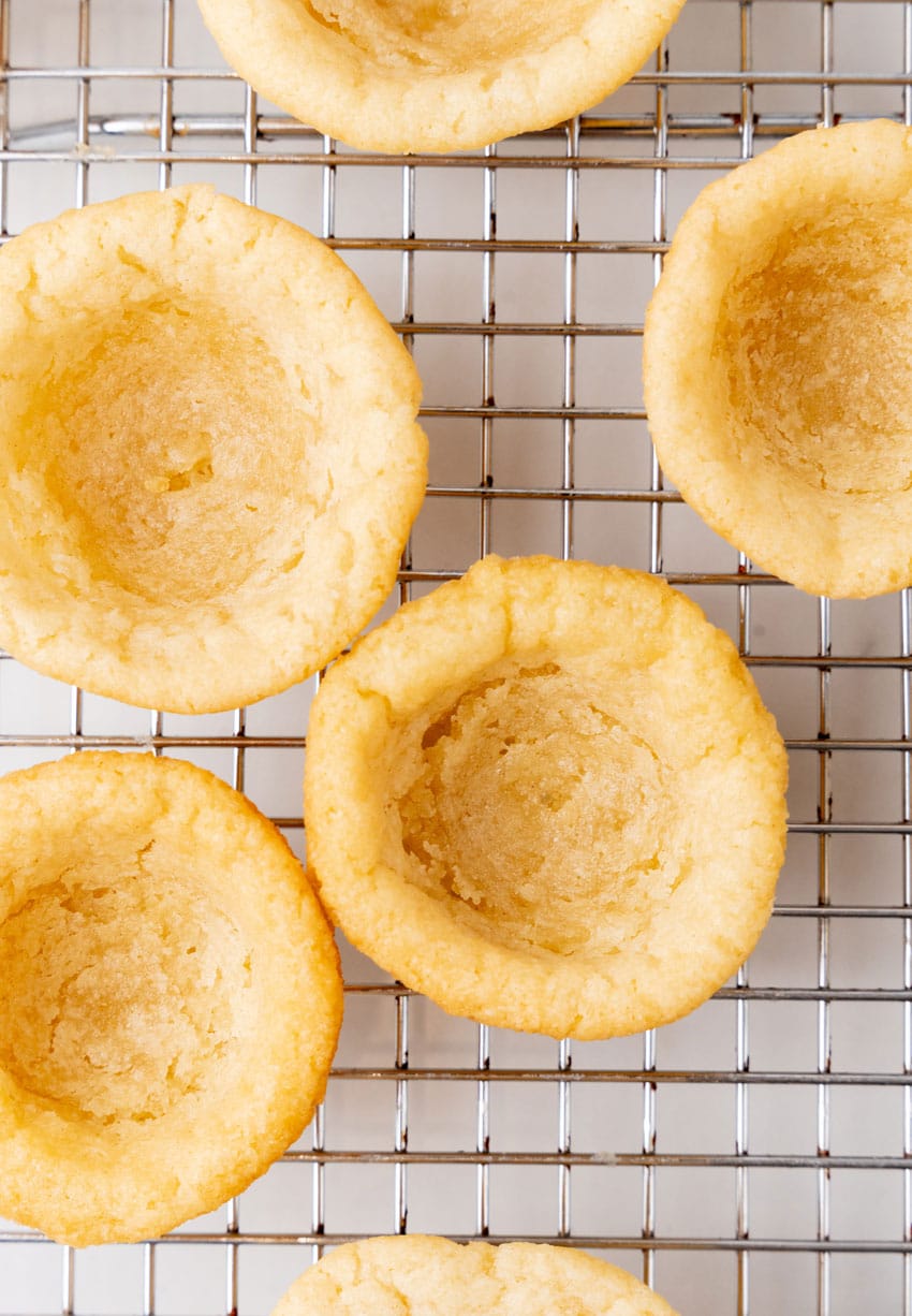 a close up of homemade sugar cookie cups cooling on a wire rack