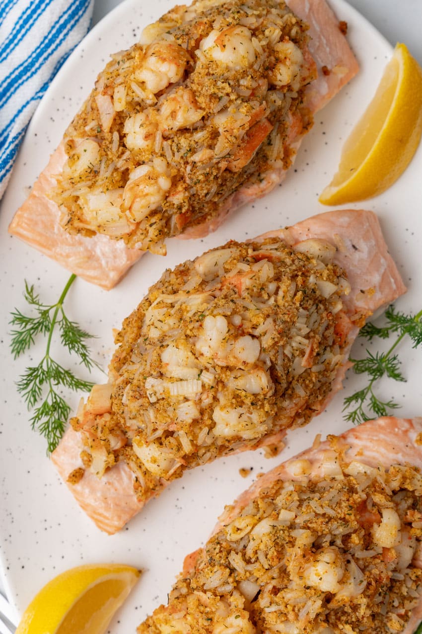 three crab stuffed salmon filets on a white serving platter