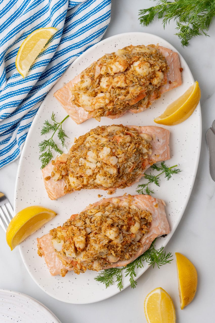 three crab stuffed salmon filets on a white serving platter