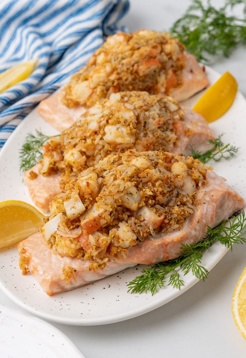three crab stuffed salmon filets on a white serving platter