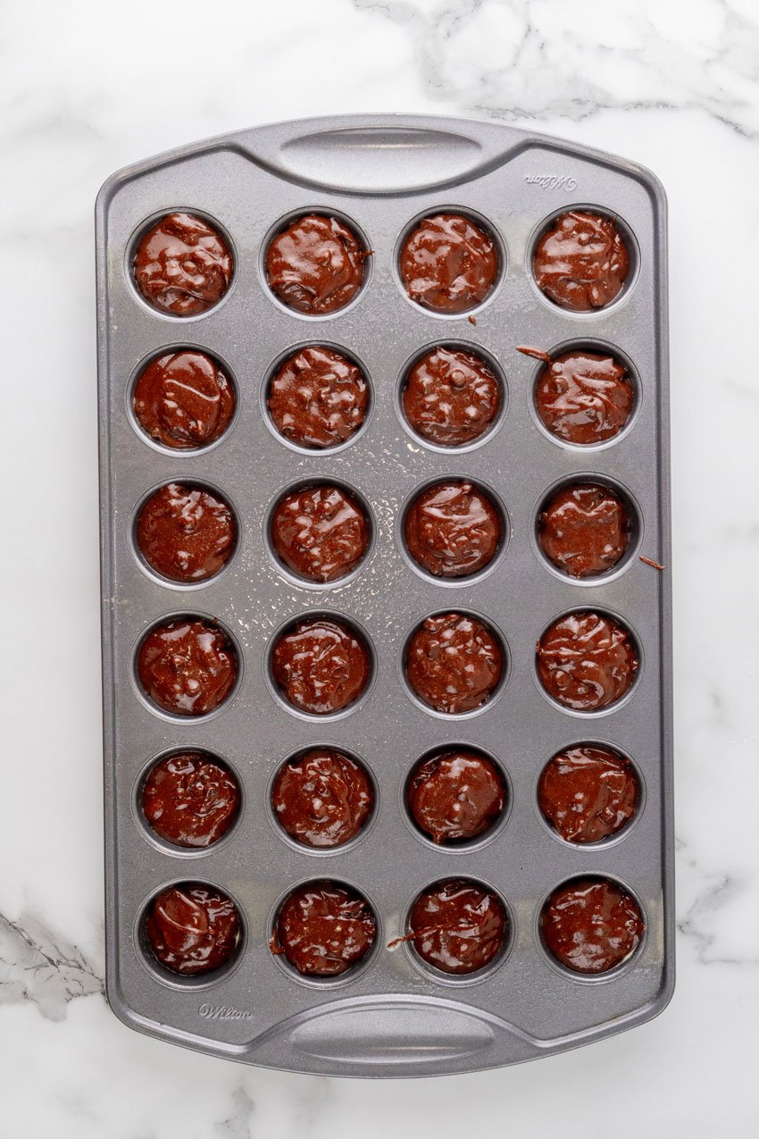 chocolate cupcake batter in a mini muffin tin