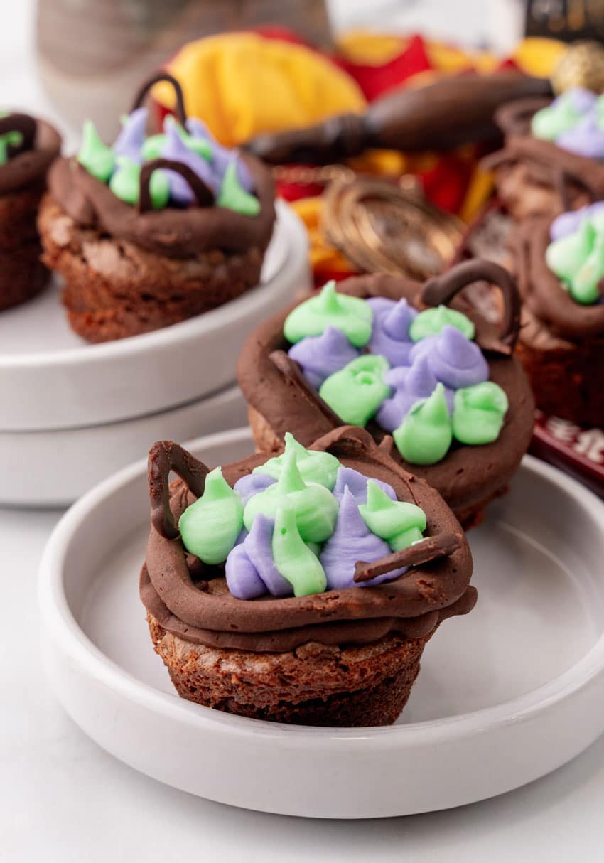 two harry potter cauldron cupcakes on a small white dessert plate