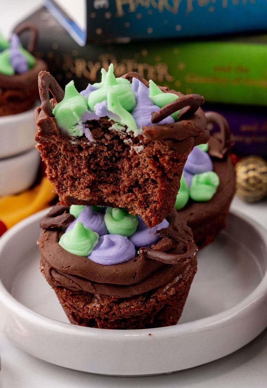 two harry potter cauldron cupcakes stacked on a small white dessert plate
