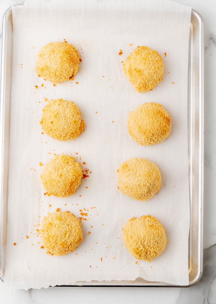 two rows of baked chicken pillows on a parchment lined baking sheet
