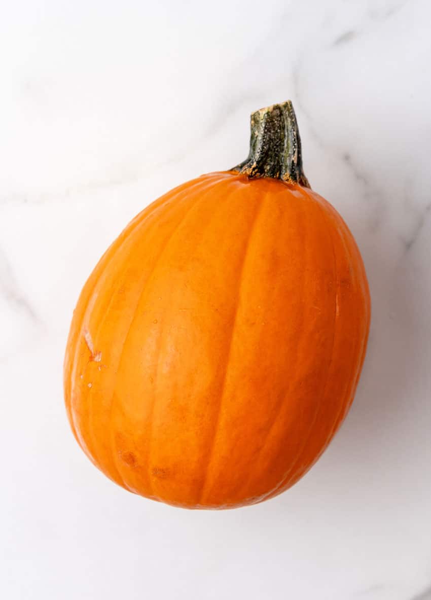 an overhead image of a whole ripe pie pumpkin