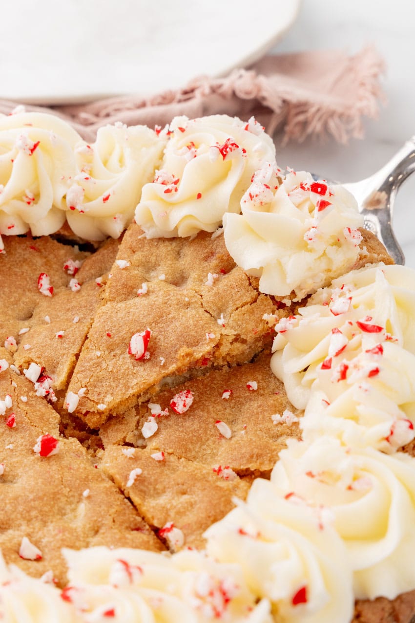 a peppermint sugar cookie cake on a marble countertop with candy canes in the background