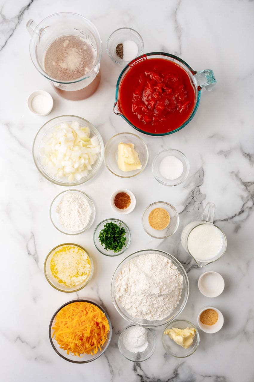 an overhead image showing the measured ingredients needed to make a batch of tomato bisque with cheddar bay dumplings