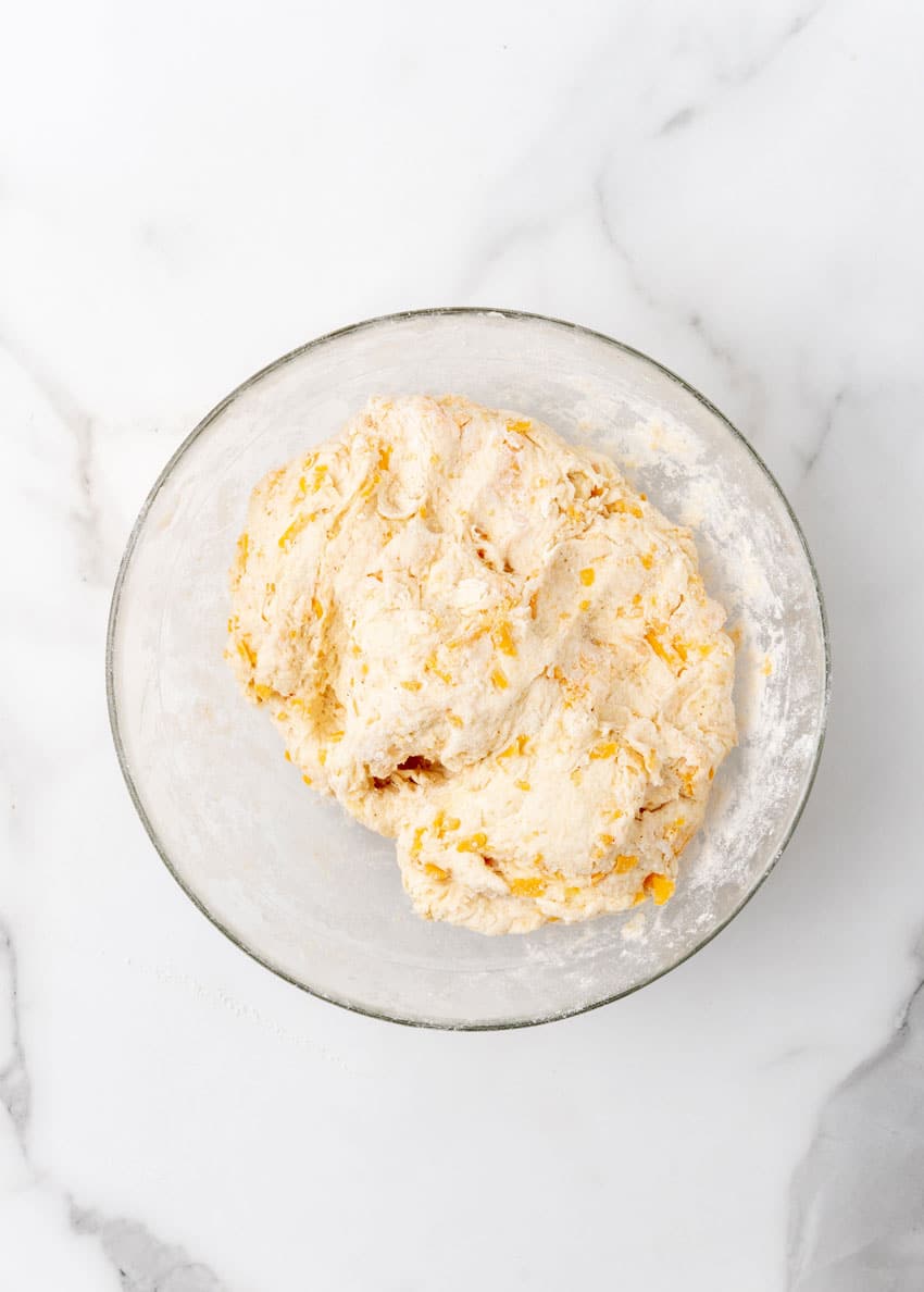 homemade cheddar bay biscuit dough in a glass mixing bowl