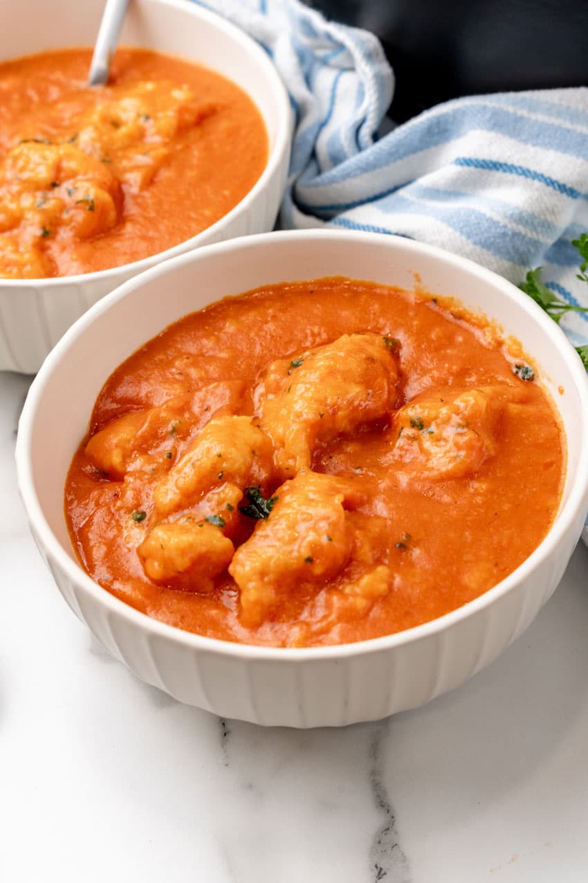 tomato bisque with cheddar bay dumplings in two white bowls