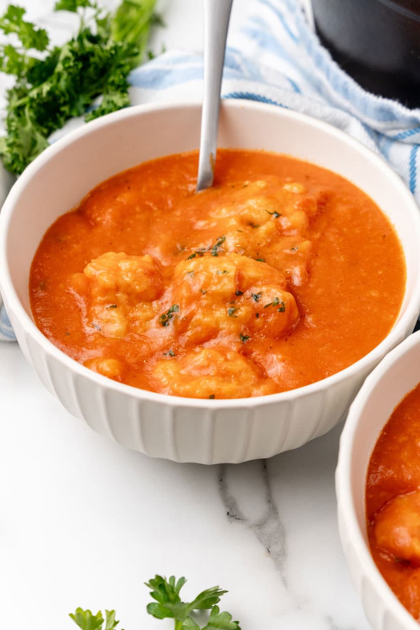 tomato bisque with cheddar bay dumplings in two white bowls