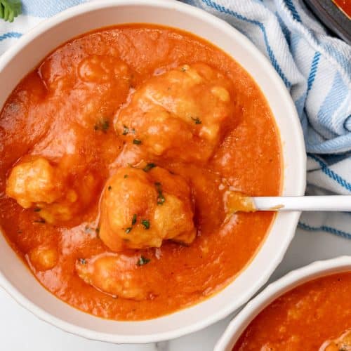 tomato bisque with cheddar bay dumplings in two white bowls