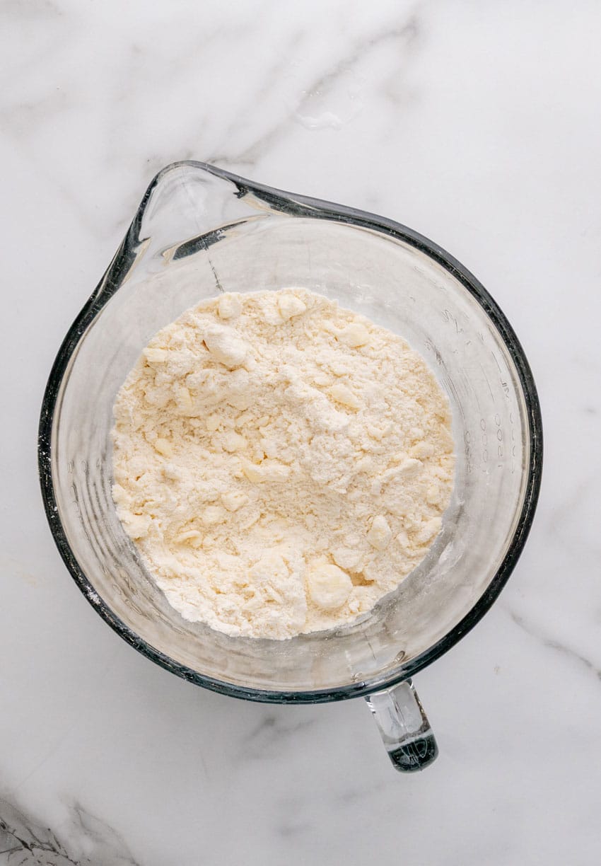 butter and flour crumbles in a glass measuring cup