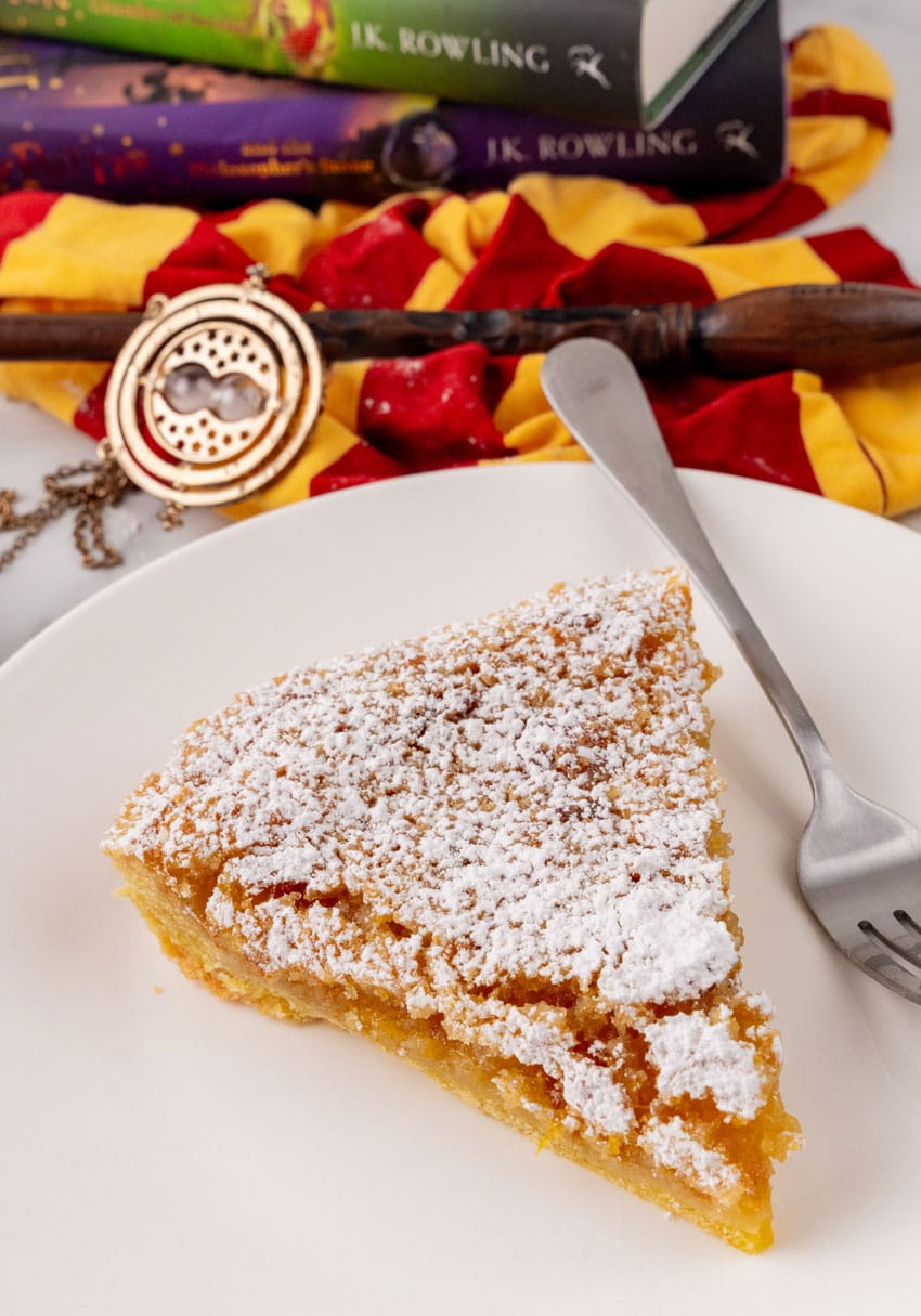 a slice of homemade treacle tart resting on a white plate