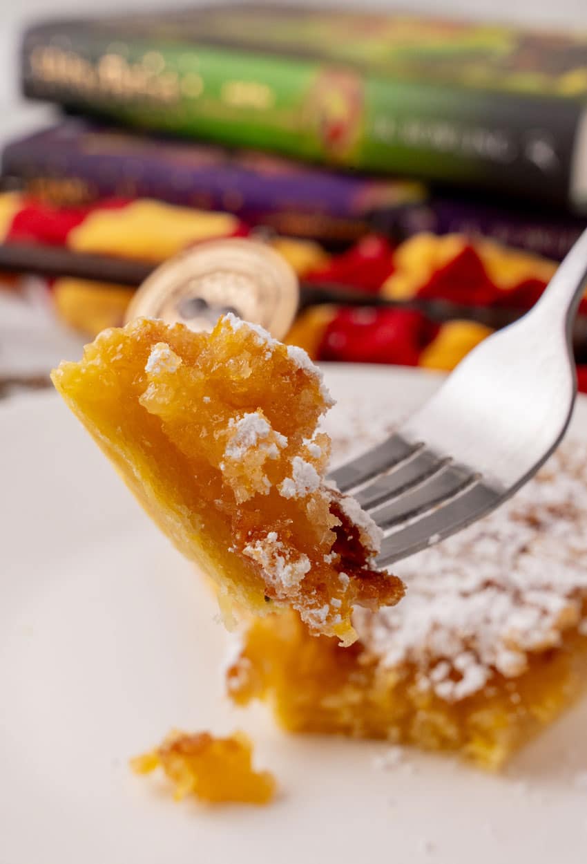 a silver fork holding up a bite of a homemade treacle tart