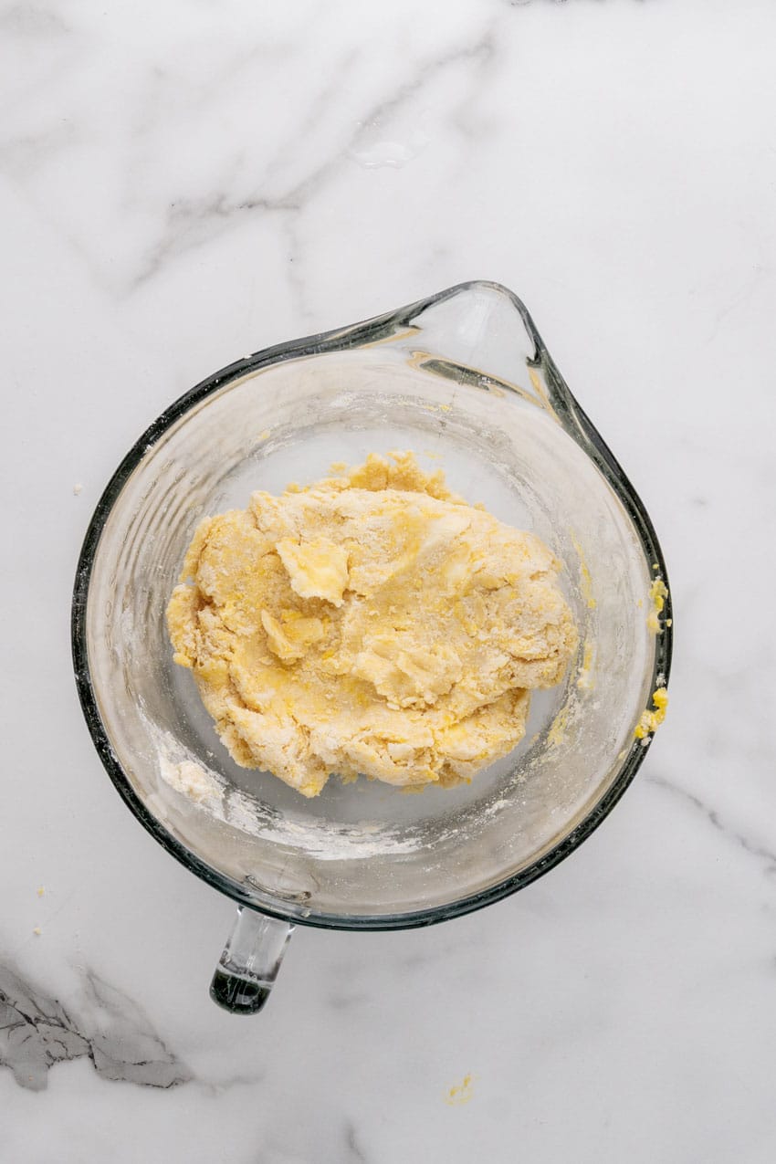 butter and flour crumbles in a glass measuring cup