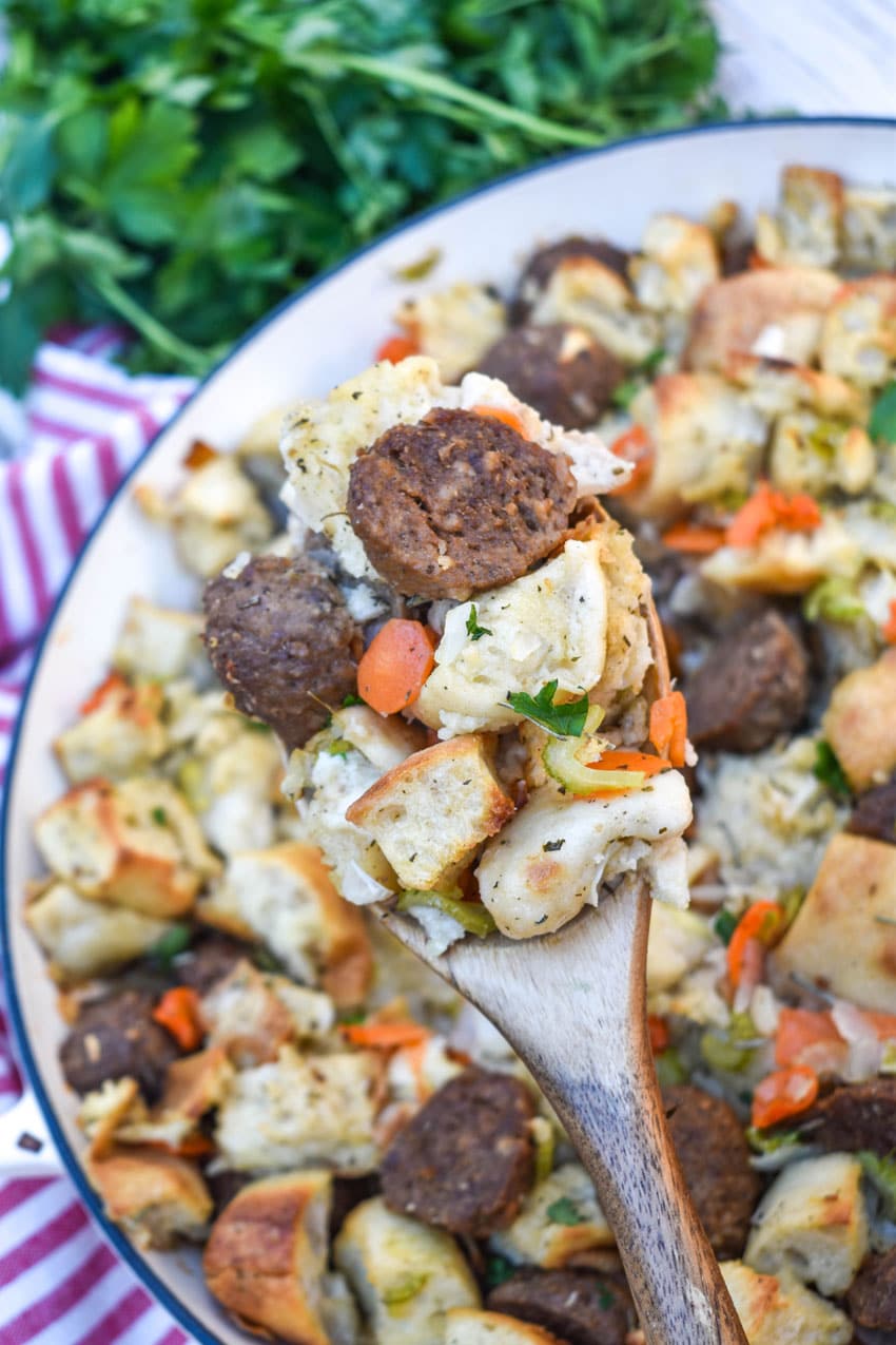 a wooden spoon holding up a scoop of ciabatta meatball stuffing