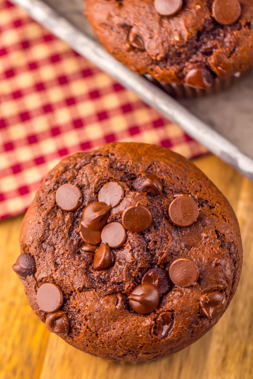 a homemade double chocolate chunk muffin on a wooden counter