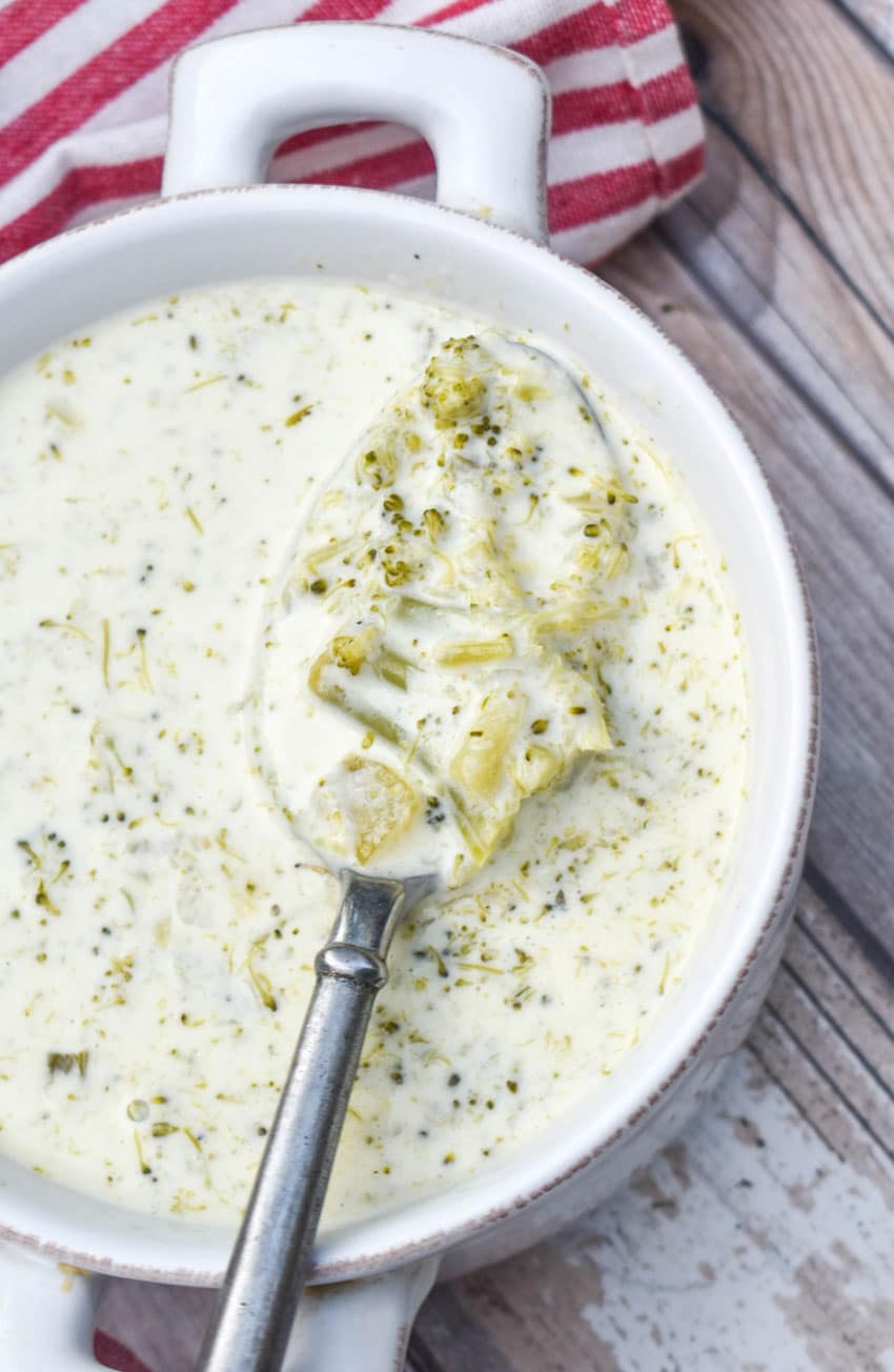 a silver spoon holding up a scoop of homemade cream of broccoli soup